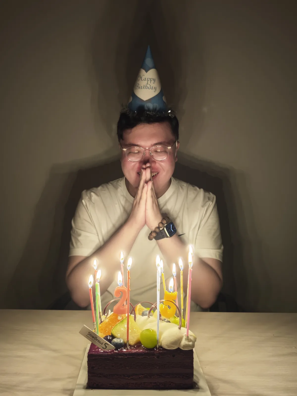 A birthday wish beside a candlelit cake